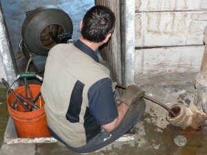 plumber using sewer plumbing snake